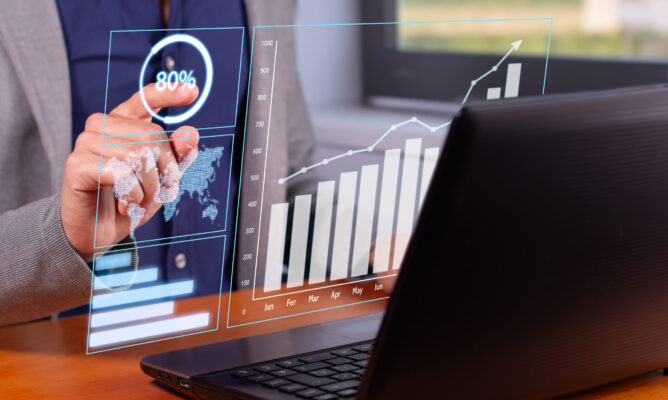 Successful Business Trends: Businessman Analyzing Rising Graphs in Modern Office